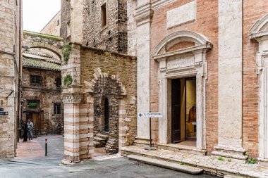 Perugia İtalya 'da bir binanın kenarındaki işaret, Umbria' nın sola doğru gittiğini gösteriyor. Bina eski ve taştan bir cephesi var.