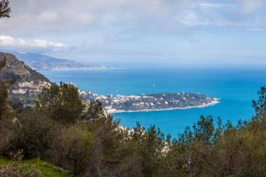 Uzakta küçük bir adası olan güzel bir manzara. Gökyüzü açık ve su mavi.