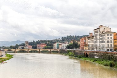 Floransa 'nın üstünden bir köprü geçen bir nehir var. Gökyüzü bulutlu ve su bulanık.