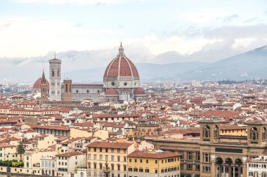 İtalya 'nın Floransa şehri Toscana' nın içinden bir nehir akan manzarası. Binalar eski ve kahverengi. Gökyüzü bulutlu.