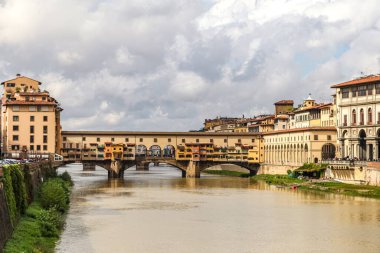 İtalya Floransa Toscana 'da Ponte Vecchio. Sarı çamurlu nehir.