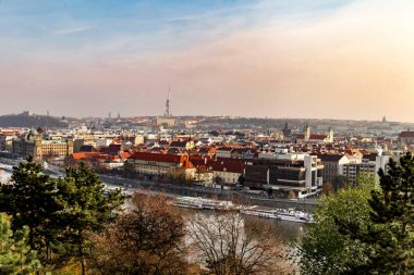 Çek Cumhuriyeti 'nin Prag şehrinin arka planında yüksek bir bina var. Gökyüzü bulutlu ve binalar yüksek.