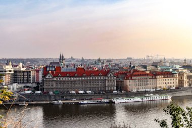 Çek Cumhuriyeti 'nin Prag şehrinin arka planında yüksek bir bina var. Gökyüzü bulutlu ve binalar yüksek.