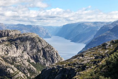Norveç 'teki dağlarda Preikestolen' e giden patikalar, fiyordu gökyüzü bulutludur. Dağlar çok yüksek ve su çok derin..
