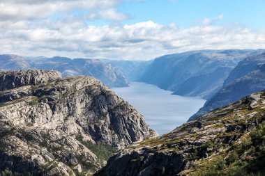 Norveç 'teki dağlarda Preikestolen' e giden patikalar, fiyordu gökyüzü bulutludur. Dağlar çok yüksek ve su çok derin..