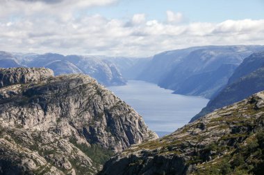 Norveç 'teki dağlarda Preikestolen' e giden patikalar, fiyordu gökyüzü bulutludur. Dağlar çok yüksek ve su çok derin..