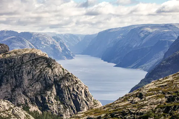 Norveç 'teki dağlarda Preikestolen' e giden patikalar, fiyordu gökyüzü bulutludur. Dağlar çok yüksek ve su çok derin..