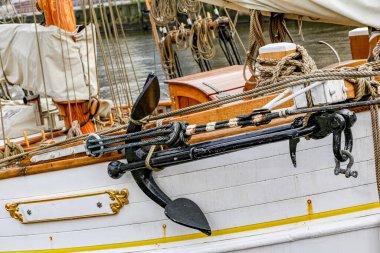 Hamburg Almanya 'sında siyah çapalı ve beyaz yelkenli bir tekne. Tekne bir rıhtıma bağlı.