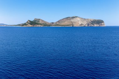 Sardunya Adası 'ndaki bir dağ mavi bir Akdeniz' in arka planındadır. Dağ ağaçlarla kaplıdır ve çok uzundur.