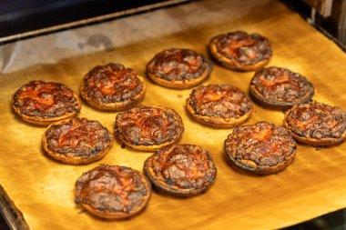 Fırın tepsisinde yanmış küçük yuvarlak pizzalar..