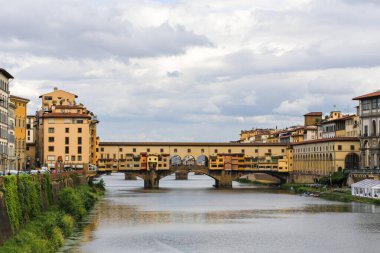 İtalya Floransa Toscana 'da Ponte Vecchio. Sarı çamurlu nehir.