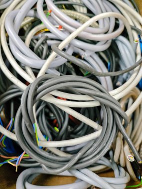 Bir sürü kablo bir kutunun içinde birikmiş. Kablolar farklı renk ve boyutlarda. Düzensizlik ve dağınıklık kavramı