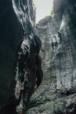 İsviçre Alplerinde küçük bir açıklığı olan dar, karanlık bir mağara. Açılışta parlayan ışık bir gizem ve merak hissi yaratır.