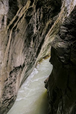 İsviçre Alplerinde dar bir Aare Vadisi 'nden bir nehir akıyor. Su beyaz ve kayalar gridir. Huzurlu ve huzurlu bir sahne.