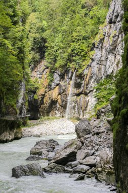 İsviçre Alplerindeki Aare Vadisi 'nde nehir akan kayalık bir uçurum. Su berrak ve kayalar gri.