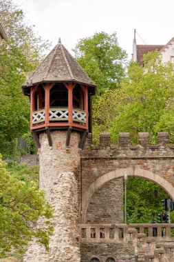 Almanya 'da Wiesbaden Federal Eyaleti Hessen' de kırmızı çatılı ve balkonlu taş bir Heidenmauer. Kule ağaçlarla çevrili ve taştan bir kemer yolu var.