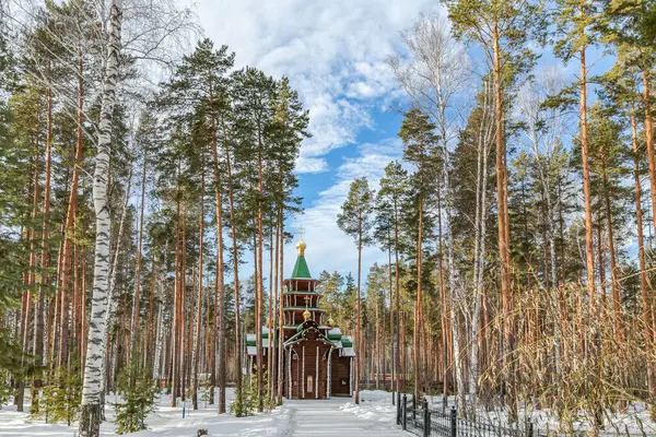 Ganina Yama 'da Yekaterenburg Rusya' da bir orman kilisesi ağaçlar ve karla çevrilidir. Kar beyaz ve ağaçlar yeşil. Kilise küçük ve ahşaptır.