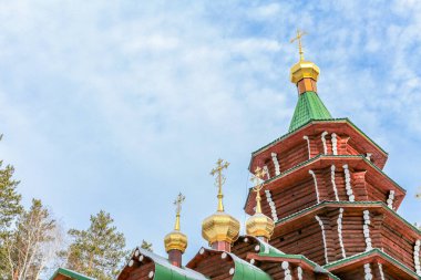 Bir grup altın ve gümüş haç bir binanın tepesinde. Haçlar farklı boyutlarda ve şekillerde ve hepsi aynı yöne bakıyor. Sahne saygı ve maneviyattır.