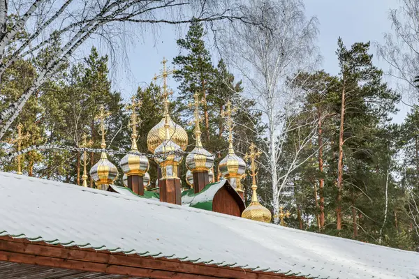 Bir grup altın ve gümüş haç bir binanın tepesinde. Haçlar farklı boyutlarda ve şekillerde ve hepsi aynı yöne bakıyor. Sahne saygı ve maneviyattır.