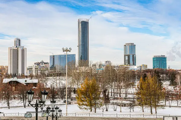 Rusya 'nın Yekaterenburg şehrinde ortasında yüksek bir bina olan bir gökyüzü. Gökyüzü bulutlu ve şehir karla kaplı.