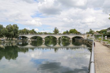 Fransa 'nın Cognac şehrinde su ve çiçek manzaralı bir köprü. Köprü eski ve kırsal bir havası var.