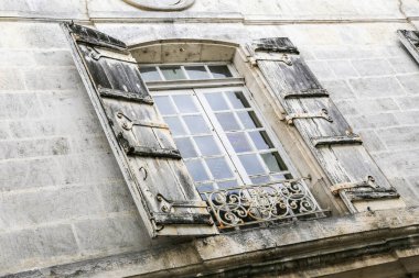 Konyak Fransa 'da panjurlu eski bir pencere açık, içeri ışık giriyor. Panjurlar eski ve yıpranmış, pencereye antika bir his veriyor.