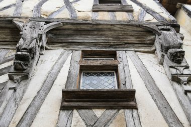Konyak Fransa 'da ahşap çerçeveli ve pencere pervazlı bir pencere. Pencere açık ve manzarası bir bina.
