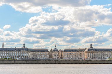 Fransa 'nın Bordeaux şehrindeki Goronne Nehri' nin karşısındaki Place de la Bourse manzarası. Gökyüzü güneşli ve bulutlu.