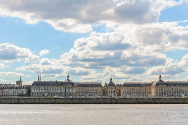 Fransa 'nın Bordeaux şehrindeki Goronne Nehri' nin karşısındaki Place de la Bourse manzarası. Gökyüzü güneşli ve bulutlu.