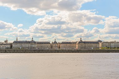 Fransa 'nın Bordeaux şehrindeki Goronne Nehri' nin karşısındaki Place de la Bourse manzarası. Gökyüzü güneşli ve bulutlu.