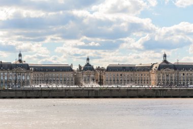 Fransa 'nın Bordeaux şehrindeki Goronne Nehri' nin karşısındaki Place de la Bourse manzarası. Güneşli ve bulutlu gökyüzü