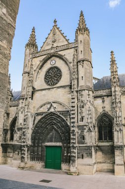 Bordeaux Fransa 'da şablonları ve yeşil ahşap kapıları olan gotik bir kilise. Gökyüzü mavi