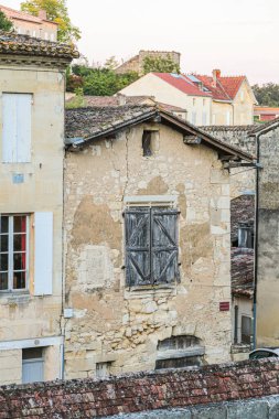 Saint Emilion Fransa 'da çitleri ve kapısı olan taştan bir bina. Kapı açık ve binanın bir sürü penceresi var.