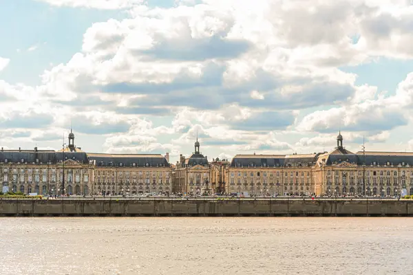 Fransa 'nın Bordeaux şehrindeki Goronne Nehri' nin karşısındaki Place de la Bourse manzarası. Gökyüzü güneşli ve bulutlu.