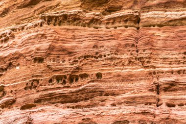 Kızıl kaya oluşumları, Almanya 'nın Saarland bölgesindeki Altschlossfelsen rezervindeki tuhaf yapıya yakın çekim yapar. Taşların parlak kırmızı ve turuncu renkli ve soyut bir şekli var..