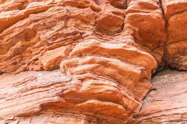 Kızıl kaya oluşumları, Almanya 'nın Saarland bölgesindeki Altschlossfelsen rezervindeki tuhaf yapıya yakın çekim yapar. Taşların parlak kırmızı ve turuncu renkli ve soyut bir şekli var..