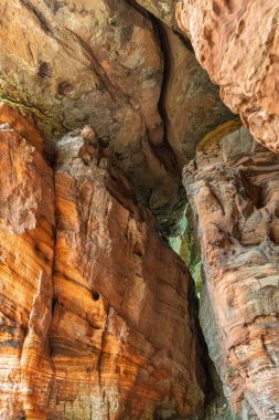 Kızıl kaya oluşumları Almanya 'nın Saarland bölgesinde Altschlossfelsen' i yedeklemektedir. Taşların parlak kırmızı ve turuncu renkli ve soyut bir şekli var..