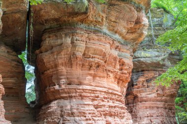 Kızıl kaya oluşumları Almanya 'nın Saarland bölgesinde Altschlossfelsen' i yedeklemektedir. Taşların parlak kırmızı ve turuncu renkli ve soyut bir şekli var..
