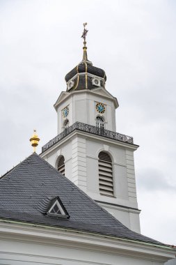 Saarbrucken Almanya 'sında cephesinde saati olan uzun beyaz bir Friedenskirche kilise kulesi. Saat 10: 00 'a ayarlandı.