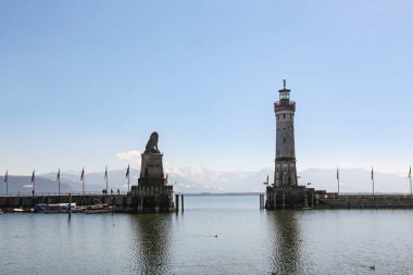 Bodensee 'de Alman kenti Lindau' da bir su kütlesinin önünde büyük bir deniz feneri bulunmaktadır. Su sakin ve gökyüzü berrak.