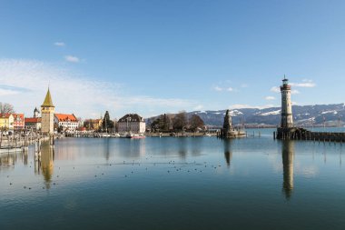 Bodensee 'de Alman kenti Lindau' da bir su kütlesinin önünde büyük bir deniz feneri bulunmaktadır. Su sakin ve gökyüzü berrak.