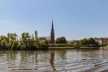 Almanya 'da ortasında büyük bir saat kulesi olan bir Frankfurt şehri silueti. Gökyüzü mavi ve güneş batıyor.