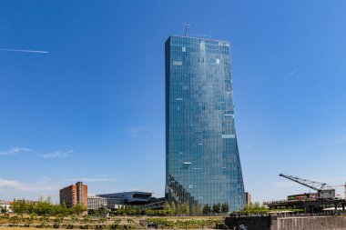 Frankfurt, Almanya 'daki liman parkında yüksek cam bir bina. Bina mavi. Arka planda mavi şeffaf bir gökyüzü var..