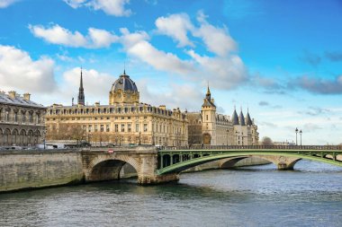Paris, Fransa 'daki Seine Nehri üzerindeki Pont Değişimi ve Conciergerie manzarası. Gökyüzü açık mavi ve bulutlu.