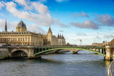 Paris, Fransa 'daki Seine Nehri üzerindeki Pont Değişimi ve Conciergerie manzarası. Gökyüzü açık mavi ve bulutlu.