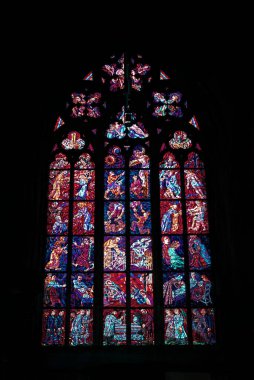 The stained glass window in St. Vitus Chapel in Prague, featuring intricate religious scenes and vibrant colors. clipart