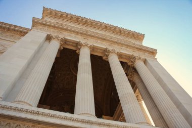 Low-angle view of grand classical columns with intricate details, showcasing the architecture of a historic building.