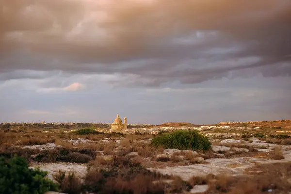 Gozo Adası 'ndaki manzara, Malta. Şehir ve kilise kubbeleri dramatik bir gökyüzü altında..