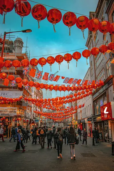 Canlı bir Londra Çin Mahallesi caddesi kırmızı fenerler ve yayalarla dolu İngiliz bayrakları ve şenlik enerjisiyle..