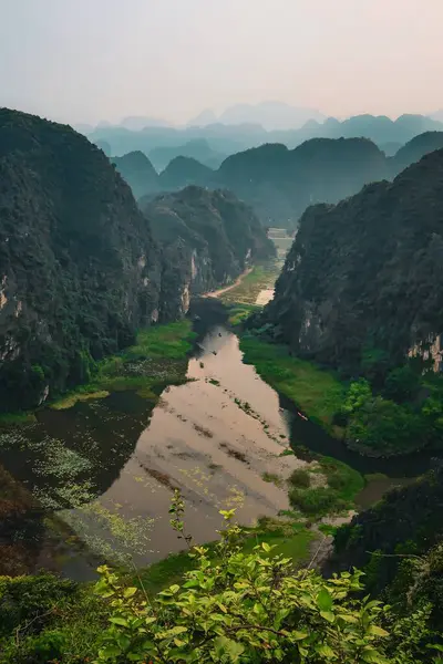 Tam Cocs 'un manzaralı nehir manzarası yemyeşil kireçtaşı uçurumlarında kıvrılarak Ninh Binh, Vietnam' da huzurlu ve pitoresk bir manzara yaratıyor..